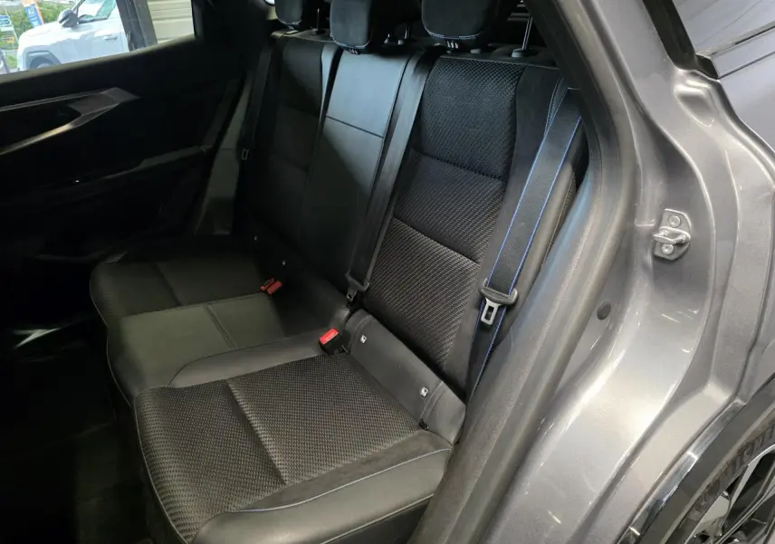 Vue côté droit de la banquette arrière noire avec surpiqûres bleues du Renault Austral gris foncé 2024.