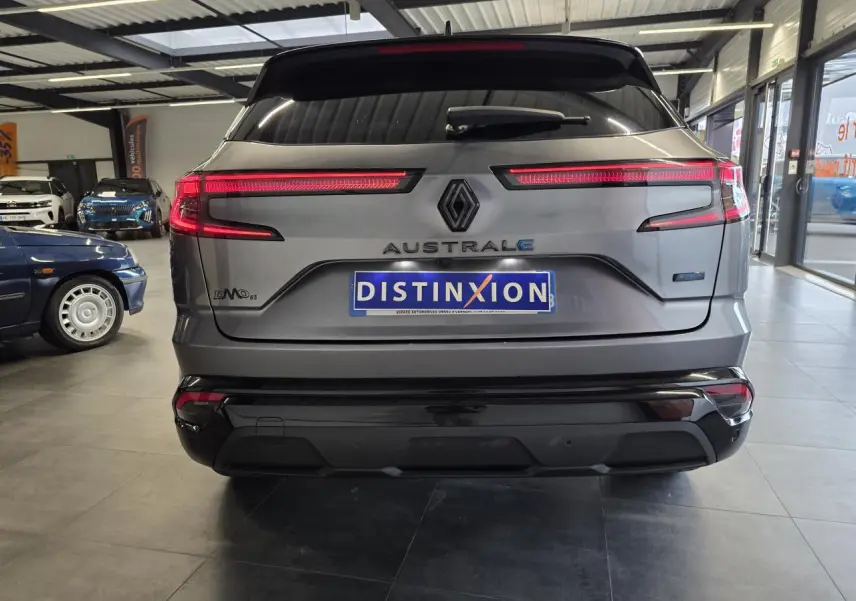 Vue arrière d'un Renault Austral gris foncé avec feux LED allumés et logo distinctif en concession.