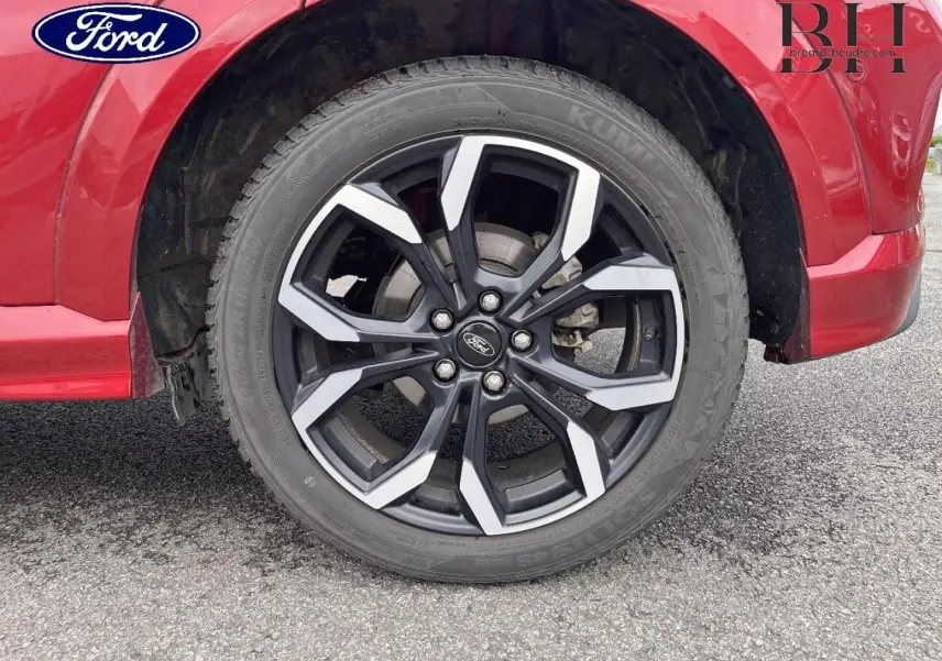 Gros plan sur la roue avant droite du Ford Puma 2020 en Premium Rouge Lucid avec jante alu noire et argentée.