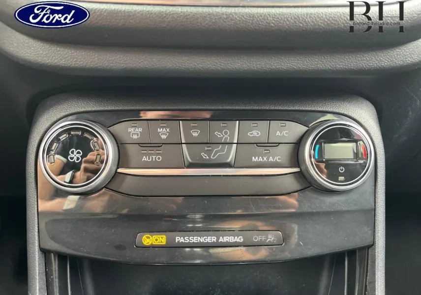 Gros plan sur la console de climatisation du Ford Puma 2020, boutons et réglages en noir brillant.