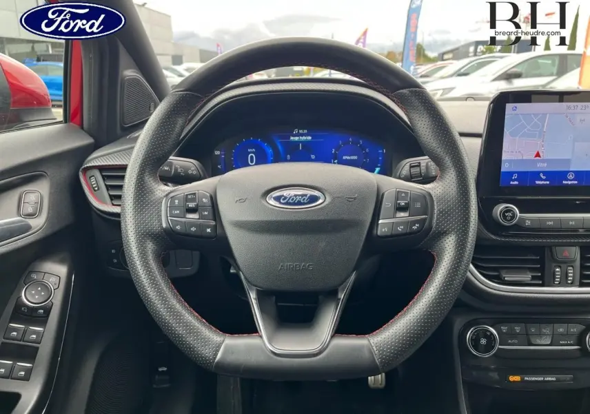 Vue intérieure centrée sur le volant cuir perforé et l'écran tactile du Ford Puma rouge Premium Lucid 2020.