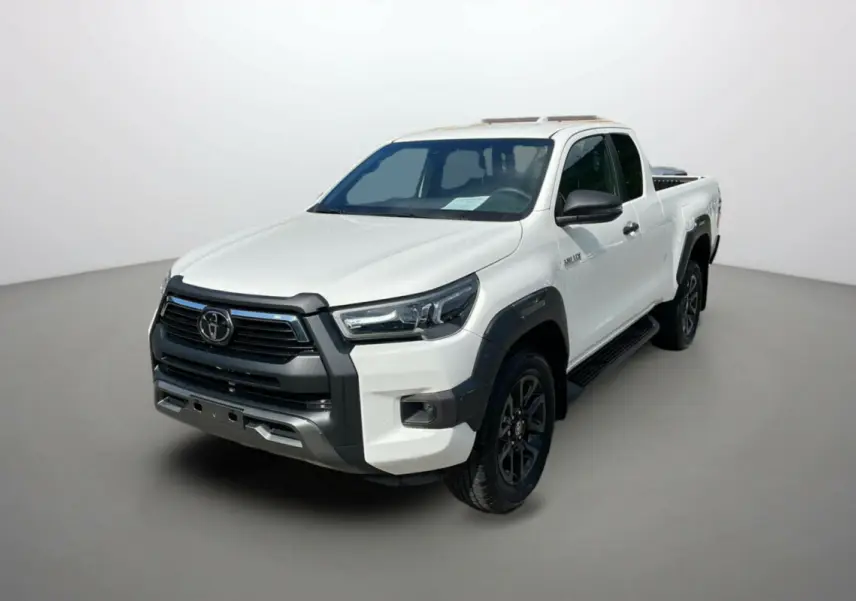 Toyota Hilux 2025 blanc pur en 3/4 avant droit, avec calandre noire et jantes noires distinctives.