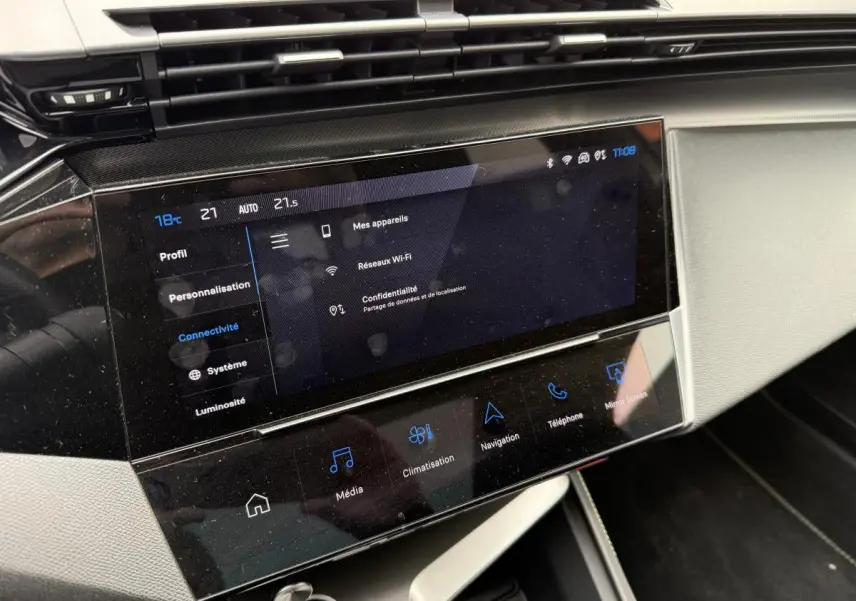 Écran tactile central 10'' du tableau de bord de la Peugeot 408 blanche, affichant les réglages de connectivité.