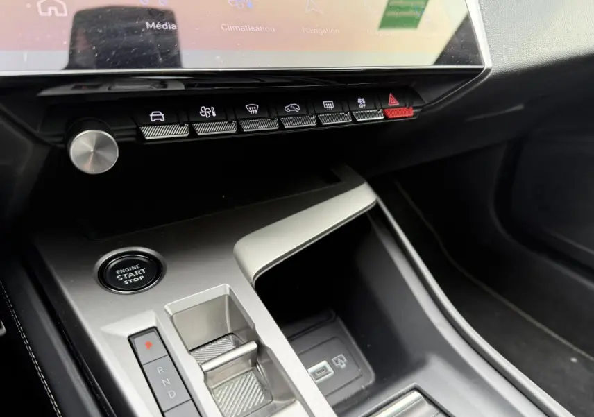 Console centrale argentée avec boutons de commande et écran tactile dans l'habitacle du Peugeot 408 blanc 2024.