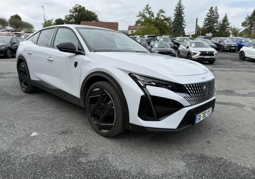 Peugeot 408 blanche vue 3/4 avant droit avec calandre noire et jantes alliage 19 pouces diamantées.