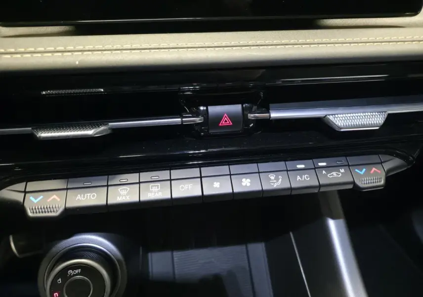 Vue rapprochée du tableau de bord de l'Alfa Romeo Tonale 2025, montrant les commandes de climatisation et le bouton de danger.