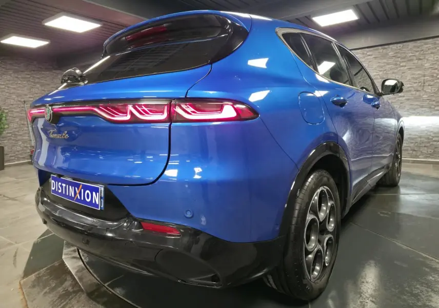 Vue 3/4 arrière droite de l'Alfa Romeo Tonale bleu métallisé avec feux arrière LED et jantes alliage 18 pouces.