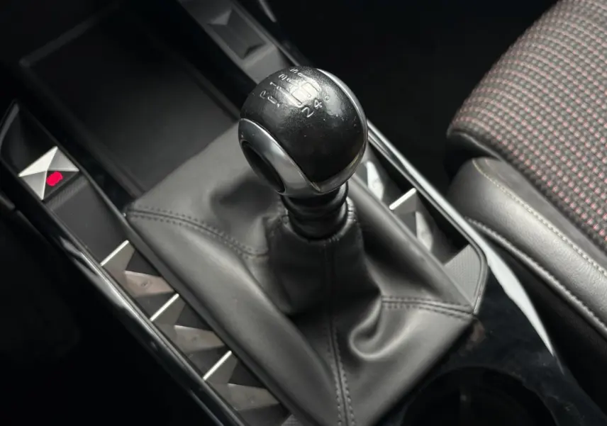 Le levier de vitesses manuel du DS3 Crossback 1.5 BlueHDI 110, avec console noire et siège tissu à motifs.