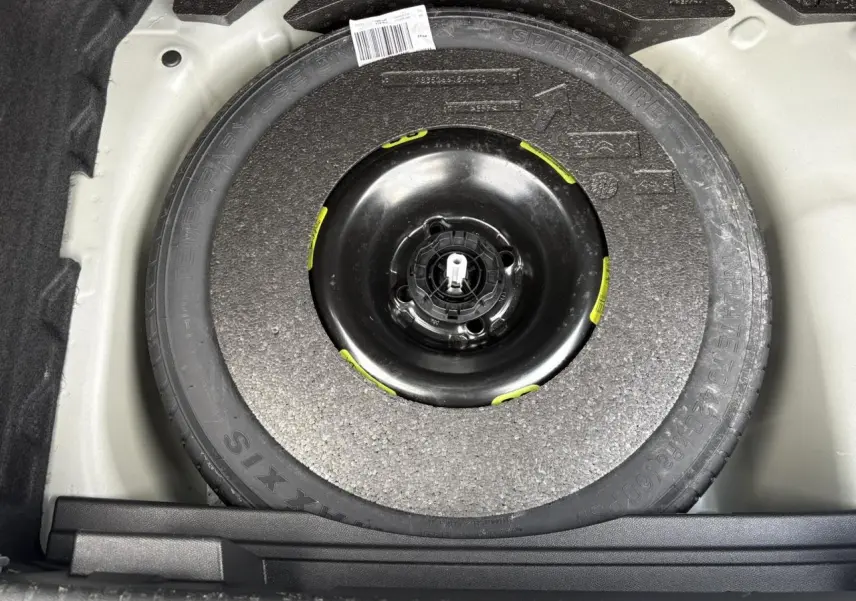 Gros plan sur la roue de secours galette noire dans le coffre du DS3 Crossback gris Artense 2021.