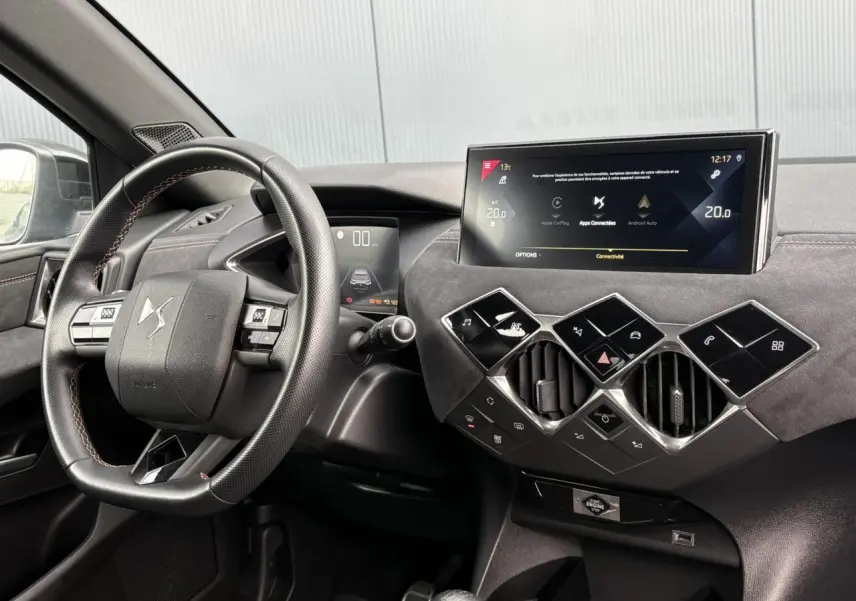 Vue intérieure du tableau de bord et volant en cuir multifonction du DS3 Crossback gris Artense avec écran tactile central.