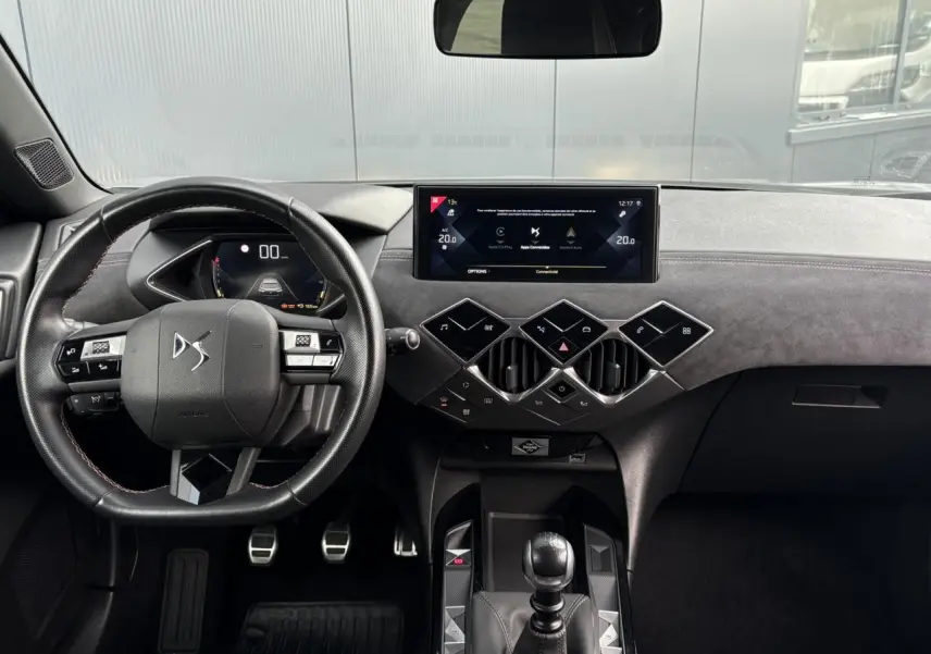 Vue intérieure frontale du tableau de bord du DS3 Crossback gris Artense, volant cuir multifonction et écran tactile central.