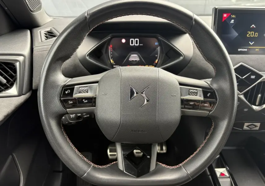 Vue rapprochée du volant en cuir noir avec logo DS, tableau de bord numérique et écran tactile du DS3 Crossback.