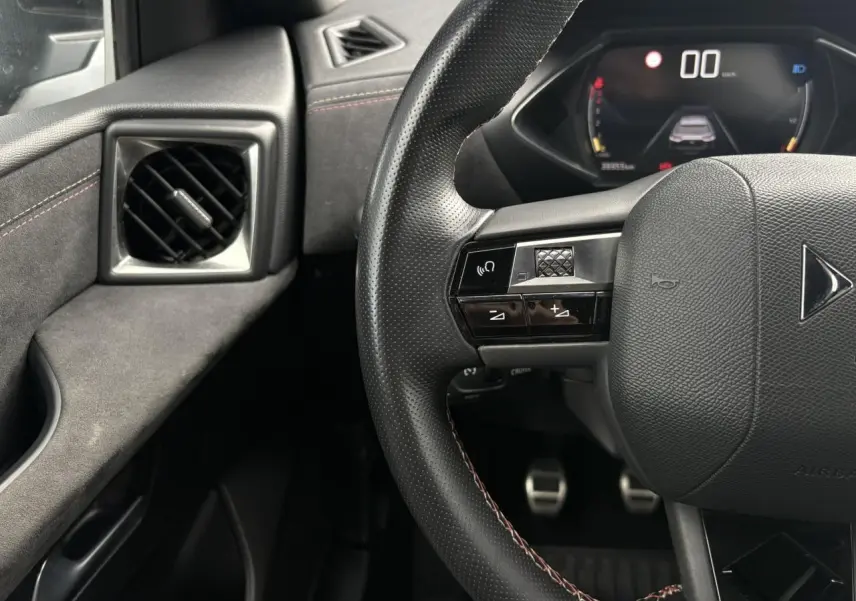 Vue rapprochée du volant en cuir noir avec commandes multifonctions et tableau de bord numérique du DS3 Crossback.