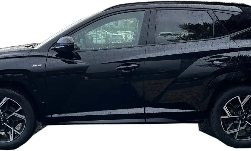 Profil côté gauche du Hyundai Tucson 2025 en noir abyss, avec jantes alliage bi-ton et badge N-Line visible sur l'aile avant.