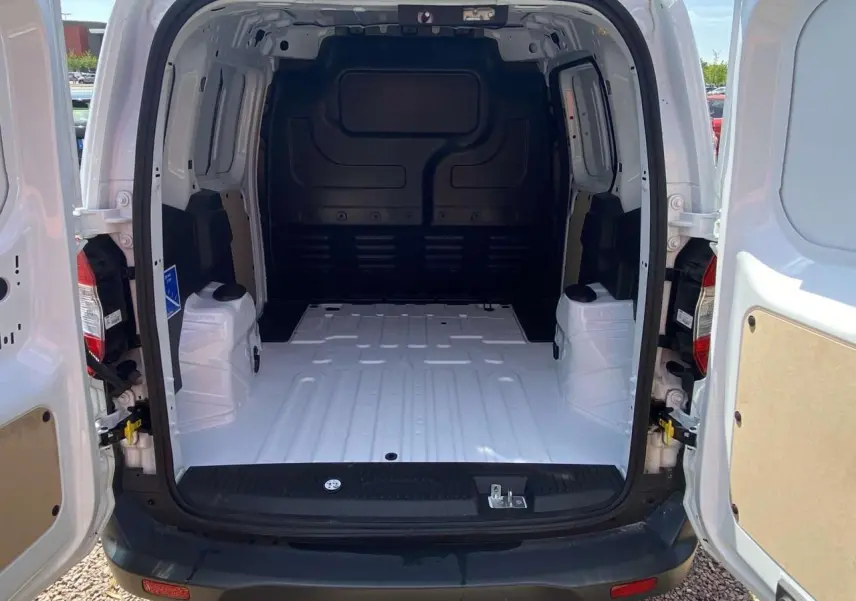 Vue arrière du fourgon Ford Tourneo Courier blanc 2022 avec portes battantes ouvertes et espace de chargement vide.