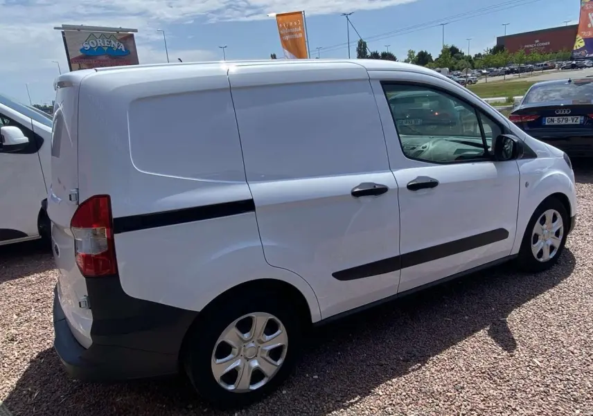 Vue 3/4 arrière droite du fourgon Ford Tourneo Courier blanc avec portes tôlées et enjoliveurs cache-moyeu.