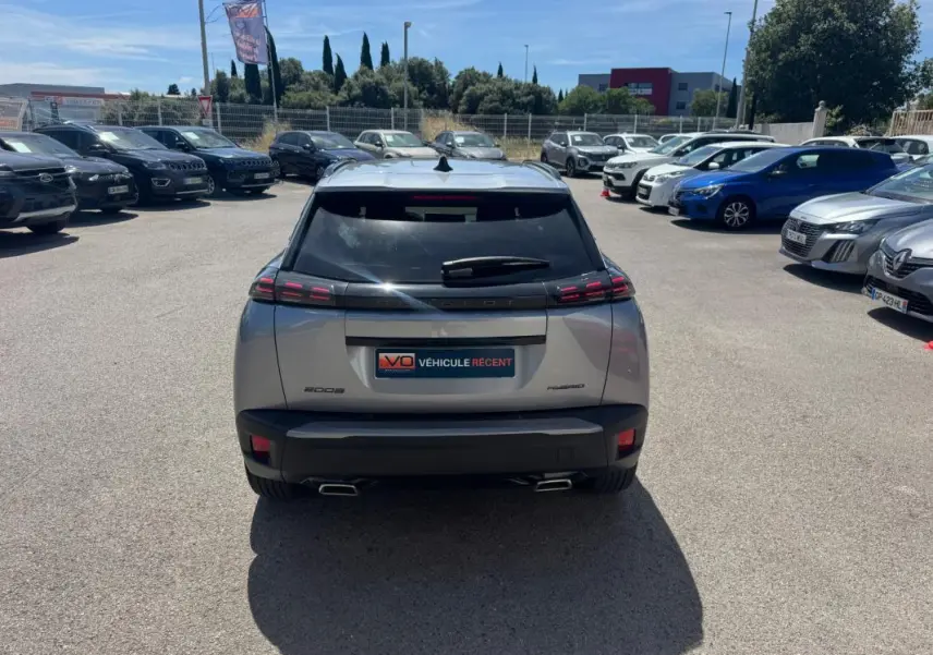 Vue arrière d’un Peugeot 2008 Hybrid 145 gris 2025 avec feux LED distinctifs et double sortie d’échappement.
