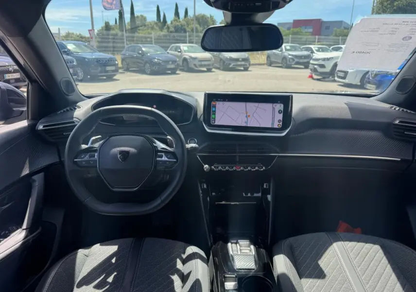 Vue intérieure avant du Peugeot 2008 Hybrid 145 Allure gris, avec volant compact, écran tactile central et cockpit numérique.