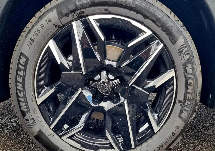 Gros plan sur la jante alu noire et argentée de la Peugeot 3008 1.2 hybrid 145 GT e-DCS6, pneu Michelin visible.