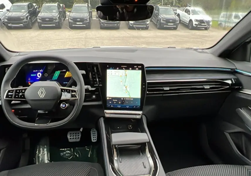 Vue intérieure du tableau de bord du Renault Austral E-Tech 200, avec écran tactile central et volant multifonction noir.