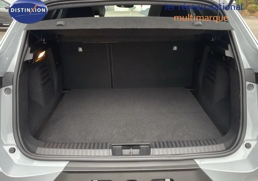 Coffre ouvert vu de l'arrière d'une Renault Symbioz gris Rafale Métal, intérieur spacieux et tapis noir.