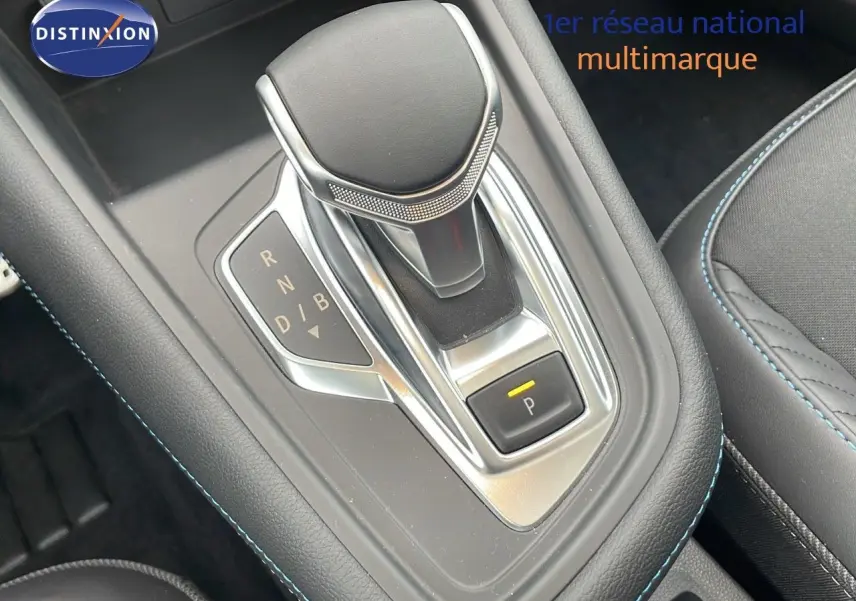 Le levier de vitesses automatique de la Renault Symbioz hybride, entouré de coutures bleues sur la console noire.