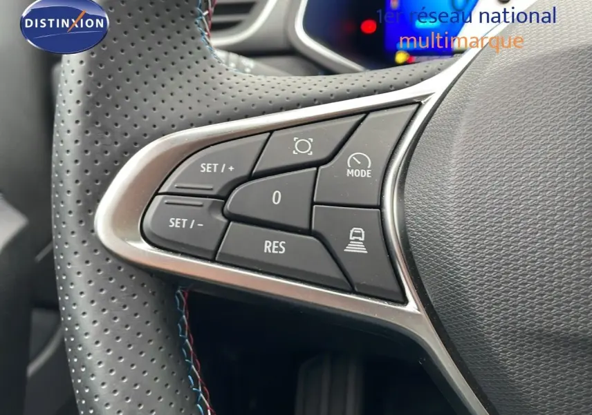 Gros plan sur les commandes du volant en cuir noir perforé de la Renault Symbioz gris Rafale, version hybride 2025.