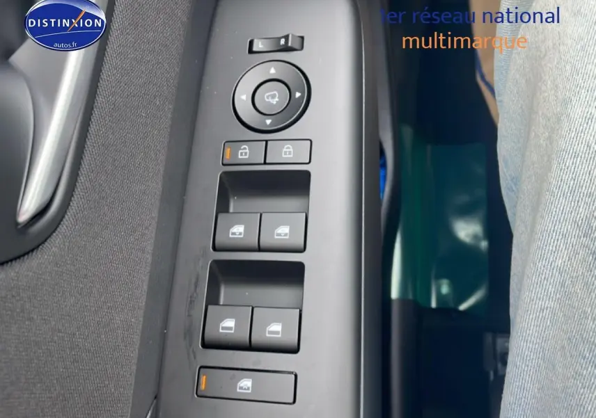 Vue rapprochée des commandes de lève-vitres et rétroviseurs sur la porte côté conducteur d'une Hyundai Kona bleu 2025.