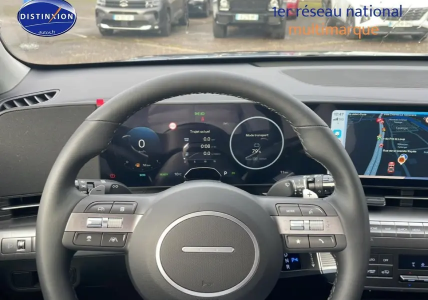 Vue intérieure centrée sur le volant cuir multifonction du Hyundai Kona 2025 avec tableau de bord numérique et écran tactile.