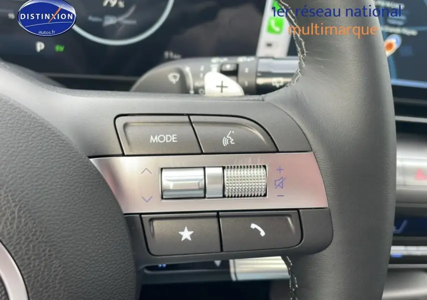 Gros plan sur les commandes gauche du volant cuir multifonction du Hyundai Kona bleu 2025, avec palettes au volant.