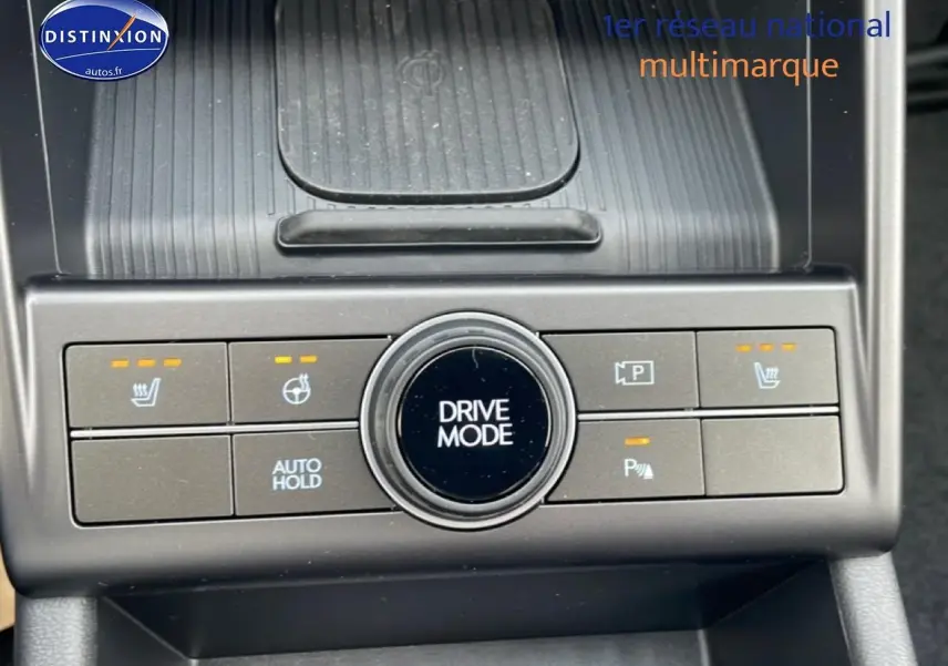 Gros plan sur la console centrale du Hyundai Kona bleu 2025, avec bouton Drive Mode et commandes chauffantes visibles.