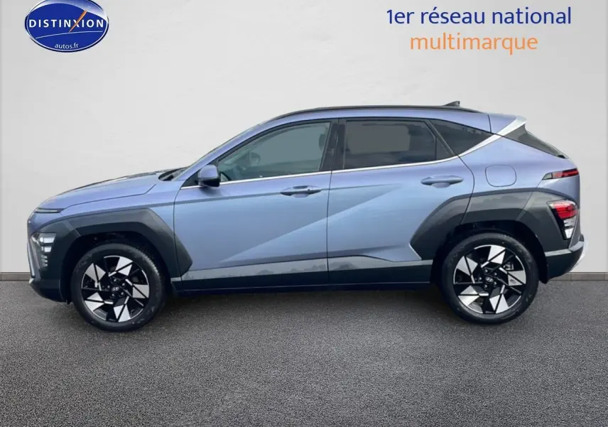 Vue de profil côté gauche d'un Hyundai Kona bleu 2025 avec jantes alliage noires et protections noires sur les ailes.