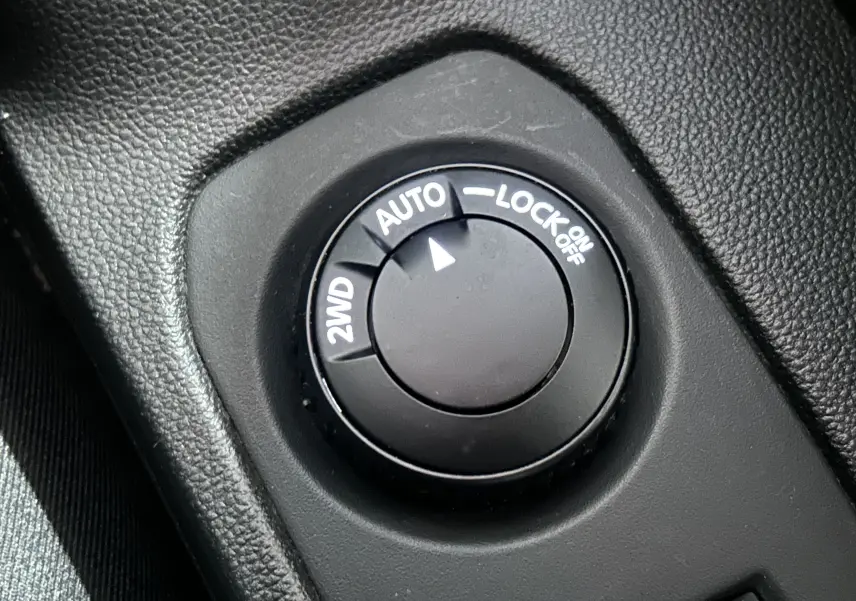 Gros plan sur le sélecteur de mode 4x4 du Dacia Duster 2023, bouton noir avec options 2WD, Auto et Lock.