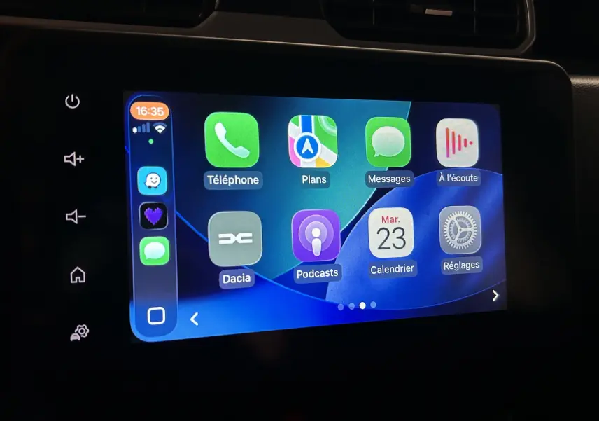 Écran tactile central du Dacia Duster 2023 affichant l’interface Apple CarPlay avec plusieurs applications visibles.