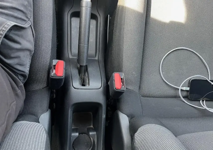 Vue intérieure centrée sur la console centrale et les sièges avant gris foncé de la Citroën C3 2023.