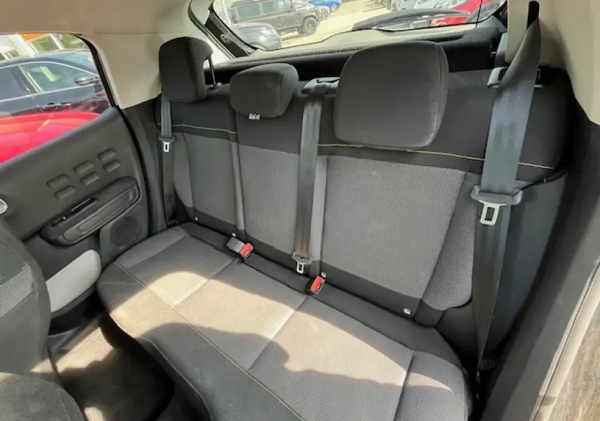 Banquette arrière en tissu gris et noir de la Citroën C3 2023, vue de côté droit avec ceintures de sécurité visibles.