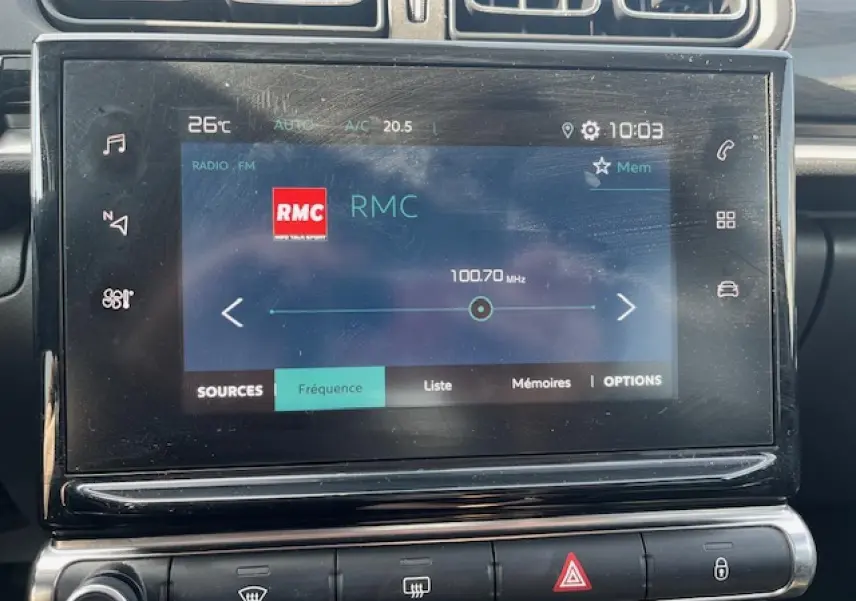 Gros plan sur l’écran tactile central de la Citroën C3 2023 affichant la radio RMC en mode FM.