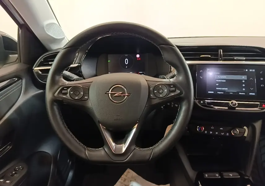 Vue intérieure centrée sur le volant cuir multifonctions noir de l’Opel Corsa avec tableau de bord digital et écran tactile.