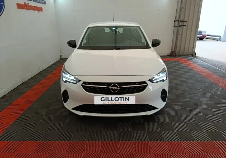 Vue frontale d'une Opel Corsa blanche 2022 avec phares LED allumés dans un garage intérieur.