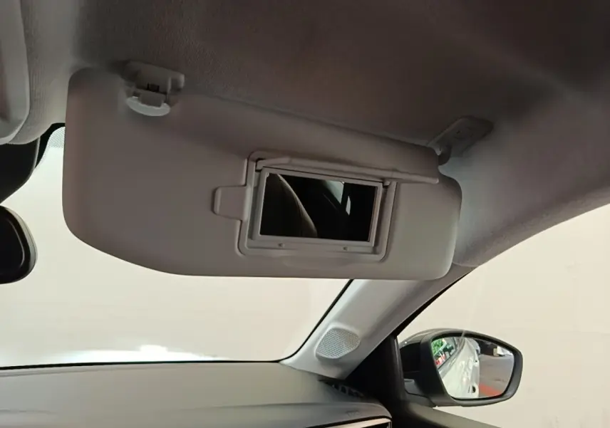 Détail intérieur du pare-soleil avec miroir ouvert côté conducteur de l’Opel Corsa blanc, vue depuis l’habitacle.