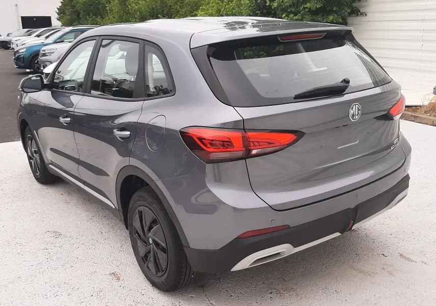 Vue 3/4 arrière droite du MG ZS 1.5 Hybrid+ 197ch en gris Camden, avec feux arrière LED et jantes noires.