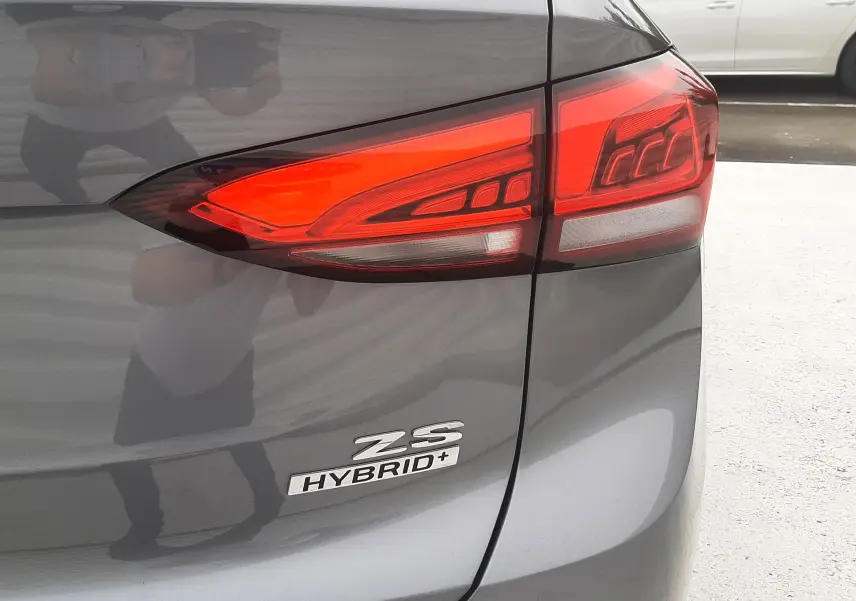 Gros plan sur le feu arrière droit d’un MG Motor ZS Camden Grey 1.5 Hybrid+ avec logo distinctif sur la malle arrière.
