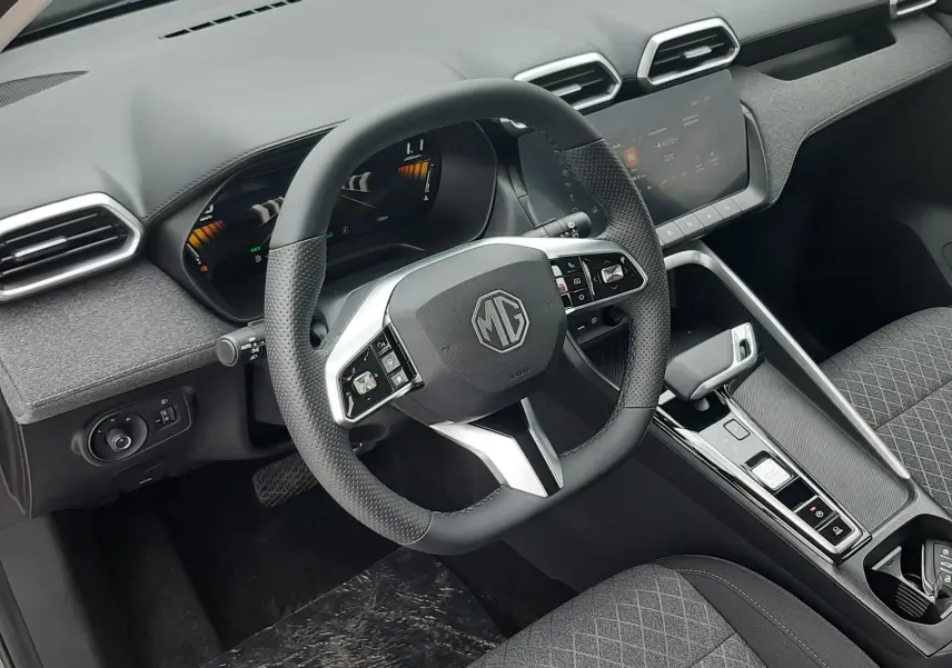 Vue intérieure du poste de conduite MG ZS 1.5 HYBRID+ 2026, volant multifonction noir et tableau de bord moderne gris Camden Grey.