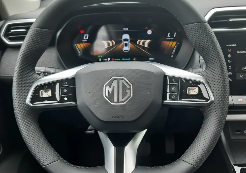 Vue rapprochée du volant perforé noir avec logo MG au centre et tableau de bord numérique du MG ZS hybride 2026.