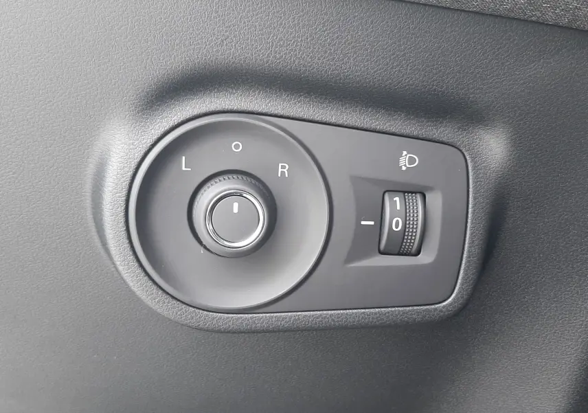 Commande de réglage des rétroviseurs et de l'éclairage sur panneau intérieur noir d'un MG MOTOR ZS Camden Grey 2026.