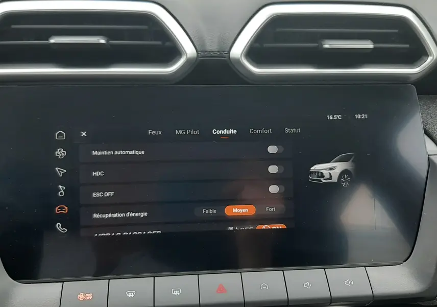 Écran tactile central du MG ZS 1.5 Hybrid+ 2026 en vue frontale, affichant les réglages de conduite, avec aérateurs hexagonaux au-dessus.