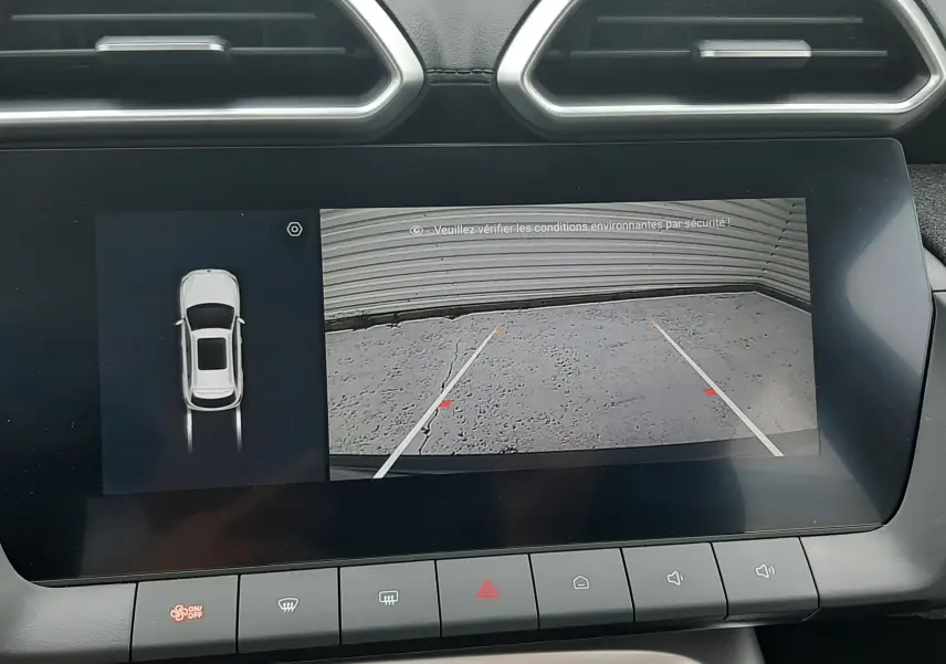 Vue intérieure du tableau de bord du MG ZS Camden Grey 2026, écran tactile affichant la caméra de recul et l'aide au stationnement.