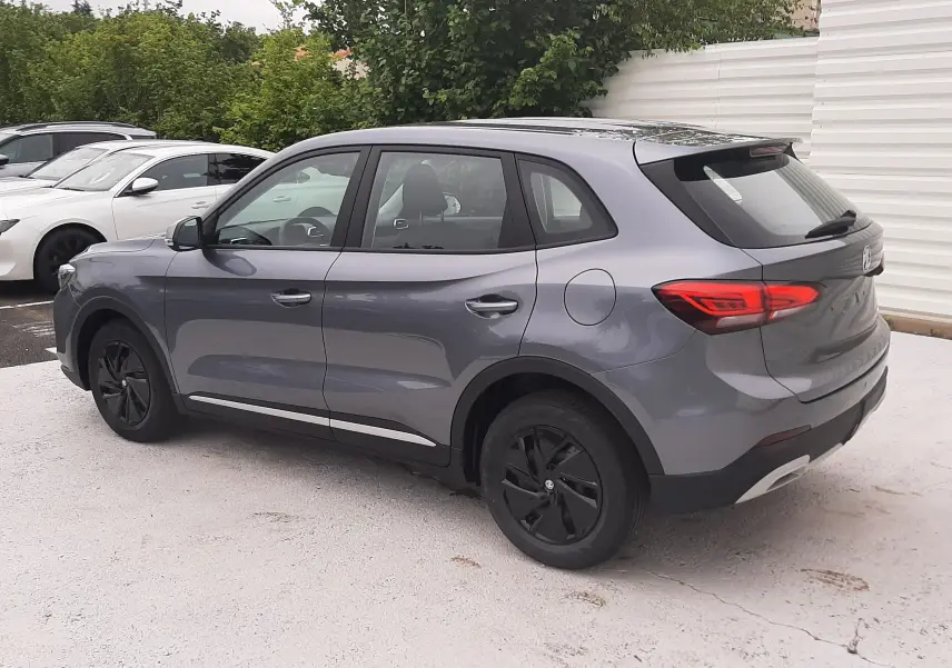 Vue 3/4 arrière côté gauche du MG ZS 1.5 Hybrid+ 197ch en Camden Grey avec jantes noires et feux arrière LED.