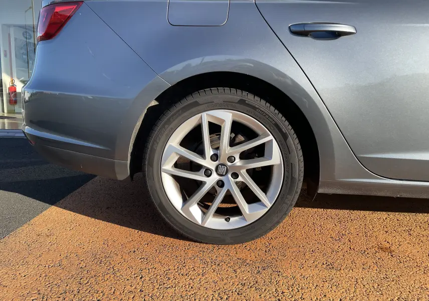 Gros plan sur la roue arrière gauche d'une SEAT LEON ST gris métallisé avec jante alliage à 5 branches doubles.