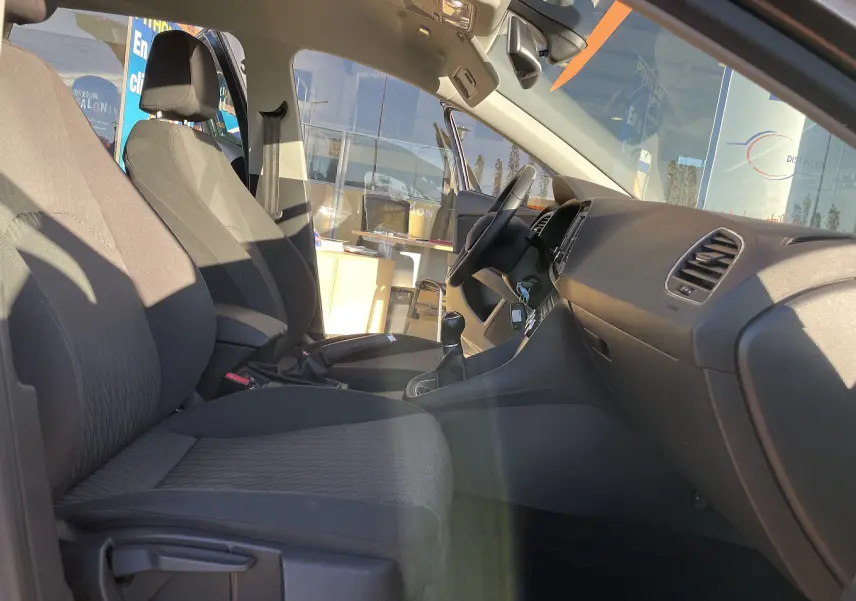 Intérieur avant côté conducteur d'une SEAT LEON ST gris 2013, sièges tissu gris-noir et tableau de bord avec boîte manuelle.